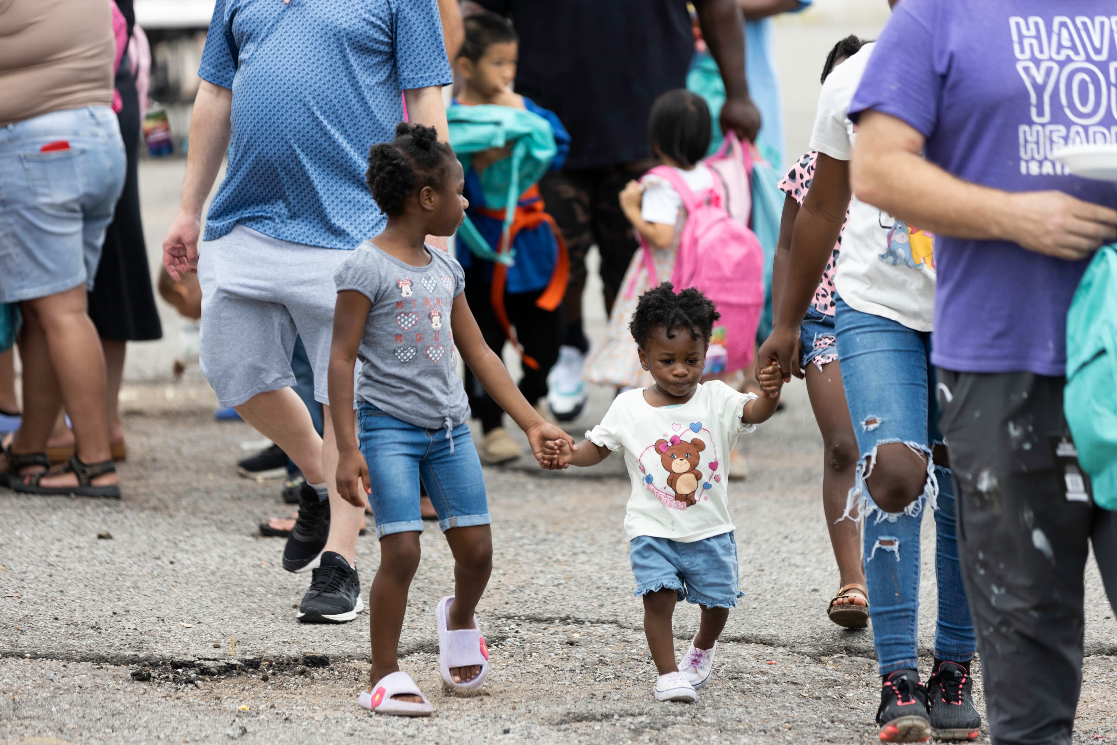 Families and students walking together with backpacks at a Back 2 School event