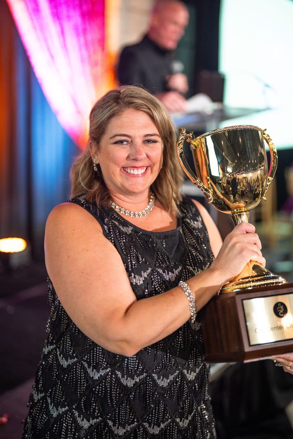 A guest holding the City Center Champion trophy during the Gala auction